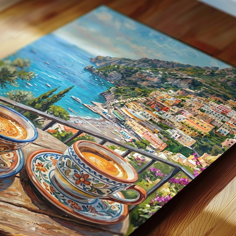 Puede incluir: Una impresi&oacute;n de arte mural rectangular que muestra dos tazas de caf&eacute; de cer&aacute;mica con intrincados patrones florales sobre platos a juego, sobre una mesa de madera con vistas a una ciudad costera con edificios coloridos, mar azul y monta&ntilde;as.