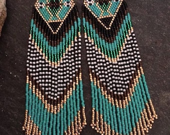 May include: A pair of long, beaded earrings with a geometric pattern in black, white, gold, and turquoise.