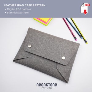 May include: A grey leather iPad case with a textured finish, fastened with two silver press studs. The image includes text that reads "LEATHER IPAD CASE PATTERN" and "neonstone PATTERNS". Pencils and sticky notes are in the background.