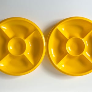 May include: Two bright yellow plastic serving dishes with five sections each. The dishes are ideal for serving snacks, dips, or appetisers.