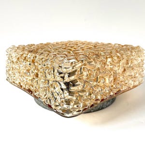 May include: A vintage, square-shaped light fixture with a textured, amber-colored glass shade. The shade has a bubbly, irregular surface. The fixture is mounted on a circular, gray metal base, creating a mid-century modern aesthetic.
