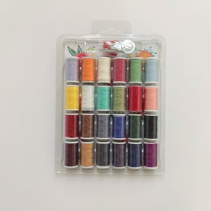 May include: A clear plastic container filled with 24 spools of colorful thread. The spools are arranged in a grid pattern and include shades of red, orange, yellow, green, blue, purple, brown, and white.