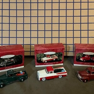 May include: Set of four Hallmark Keepsake Ornament collectible series cars. The cars are a 1939 Ford Pickup Truck, a 1957 Chevrolet Sedan Delivery, a 1953 Ford F-1 Pickup Truck, and a 1949 Chevrolet 3100 Pickup Truck. Each car is red and white, green and white, or red and black.