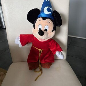 May include: A white ceramic mug with a black handle and the text "But First, Coffee" in a bold, black font. The mug is set against a neutral background, highlighting its simple design.