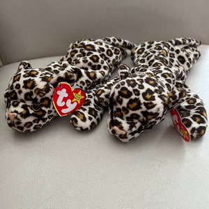 May include: Two brown and white leopard print beanie babies with red and white Ty tags.