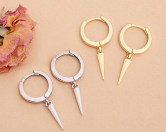 May include: Two pairs of hoop earrings with a pointed dangle. One pair is gold and the other is silver.