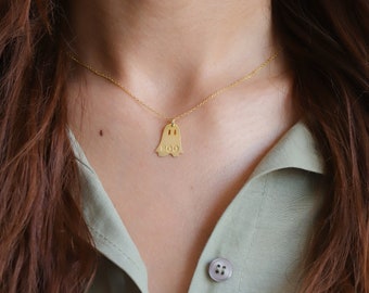 May include: A gold necklace with a ghost-shaped pendant that says "BOO" on it.