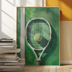 May include: Watercolor tennis art print featuring a tennis racket and ball against a green background. The racket is white with a green net, and the ball is a pale yellow-green. The artwork is framed in a light wood frame.