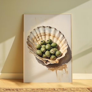 Könnte beinhalten: Ein gerahmtes Kunstwerk mit einer großen Muschel, gefüllt mit grünen Oliven. Die Muschel ist in Beige- und Brauntönen gemalt, und die Oliven sind ein leuchtendes Grün. Das Kunstwerk wird an einer hellen Wand ausgestellt.