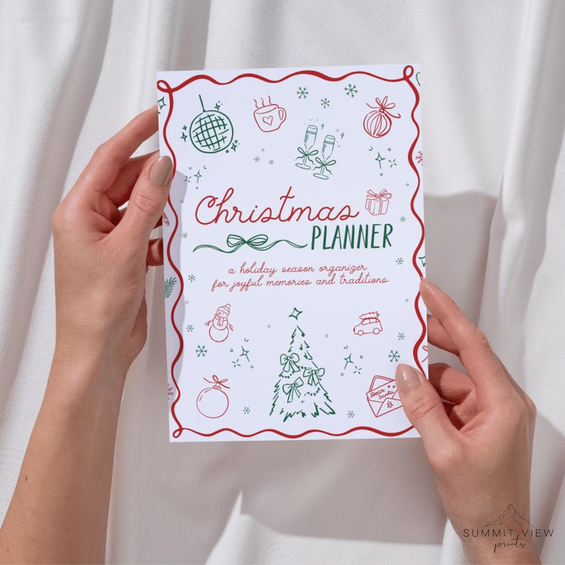 May include: A white Christmas planner with red and green illustrations and text. The cover features the words "Christmas Planner" with a bow design, surrounded by festive drawings of ornaments, a Christmas tree, and snowflakes. The text reads "a holiday season organizer for joyful memories and traditions."
