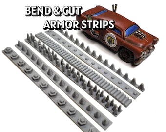 May include: Gray armor strips with various designs and a brown toy car with blue windows. The text "BEND & CUT ARMOR STRIPS" is displayed above the strips. The strips have different shapes, including cones and hexagonal shapes.