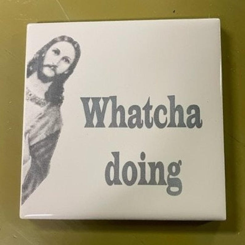 A white ceramic tile with a black and white image of Jesus peeking from the left side, and the words "Whatcha doing" in gray text.