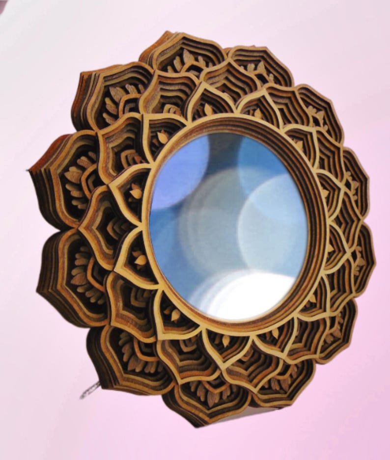 A multi-layered wooden mandala mirror with an intricate petal frame shown against a light pink background.