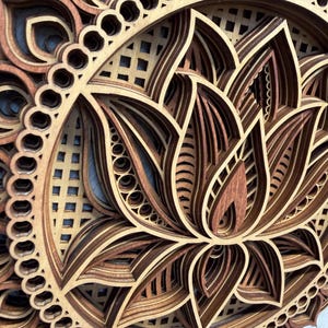 A very close-up, angled view of a layered wooden lotus mandala, highlighting the detailed laser-cut patterns and different wood shades.
