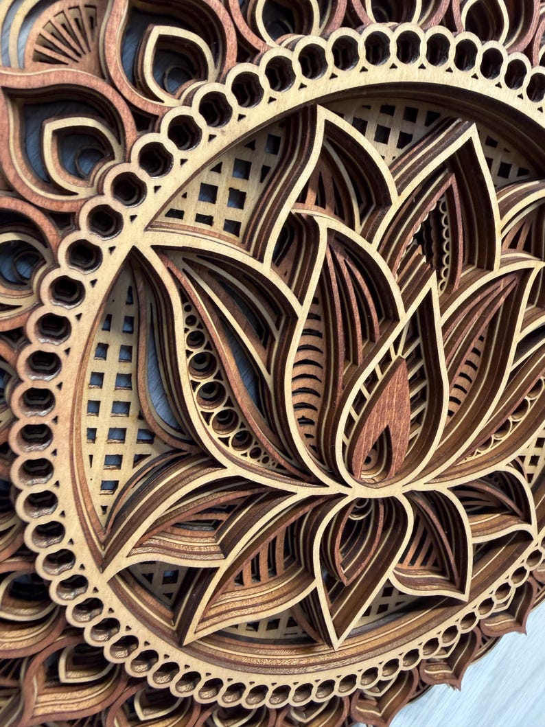 A very close-up, angled view of a layered wooden lotus mandala, highlighting the detailed laser-cut patterns and different wood shades.