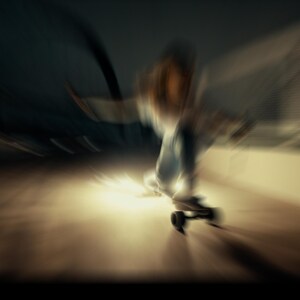 Puede incluir: Una persona montando un longboard de noche con un fondo borroso.