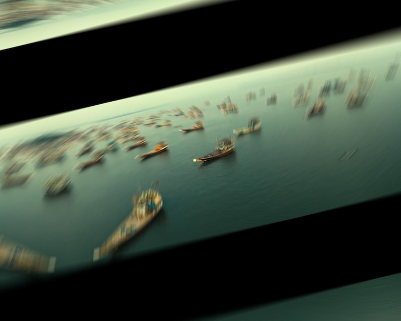 Puede incluir: Vista a&eacute;rea de un gran grupo de barcos de pesca de madera en una masa de agua. Los barcos est&aacute;n todos orientados en la misma direcci&oacute;n y est&aacute;n agrupados.