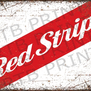 Op de afbeelding: Een vintage metalen bord met een diagonaal rood-wit gestreept ontwerp. De woorden "Red Stripe" zijn in wit op de rode streep gedrukt.