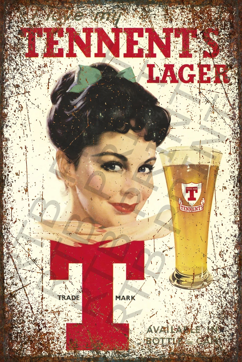 Op de afbeelding: Een vintage metalen bord dat reclame maakt voor Tennent's Lager. Het bord toont een vrouw met een groene strik in haar haar, die naar de kijker kijkt. Een glas bier met het Tennent's-logo staat op de voorgrond. Het bord heeft een roestige, verweerde uitstraling.