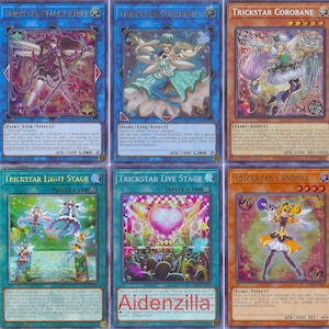 Puede incluir: Una colecci&oacute;n de diez cartas coleccionables coloridas de la serie "Trickstar". Cada carta tiene un dise&ntilde;o &uacute;nico con personajes de fantas&iacute;a y texto. Las cartas son de varios colores, incluyendo azul, naranja y verde.
