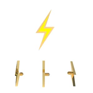May include: Gold-colored lightning bolt shaped metal charm with a screw back. The charm is shown from the front, side, and back views.