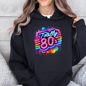 May include: Black hoodie with a colorful graphic print of the text "Totally 80's" in a neon style with rainbow accents.