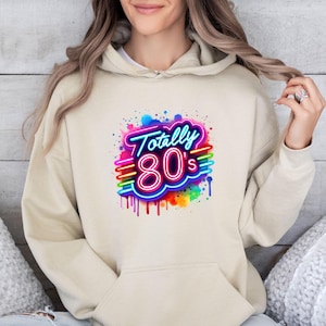 May include: A beige hoodie with a colorful graphic print that says "Totally 80's" in a neon style.