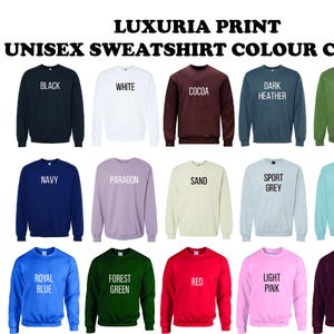 May include: A color chart of unisex sweatshirts in various colors, including black, white, cocoa, dark heather, military green, navy, paragon, sand, sport grey, stone blue, royal blue, forest green, red, light pink, and maroon. The text "LUXURIA PRINT" and "UNISEX SWEATSHIRT COLOUR CHART" are displayed.