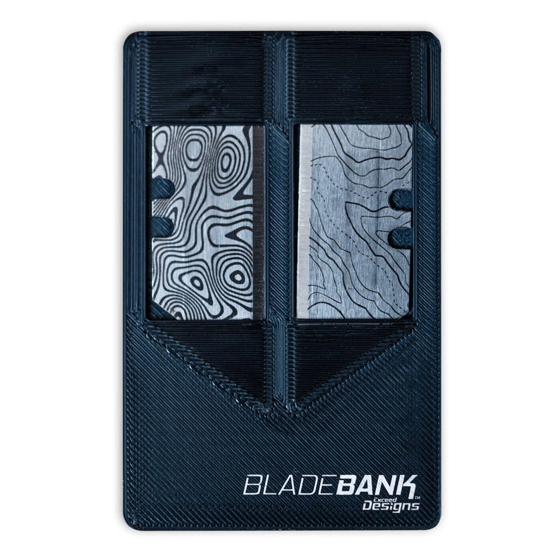 May include: A black plastic card holder with two slots for razor blades. The card holder has the text "BLADEBANK. exceed Designs" printed on the bottom.