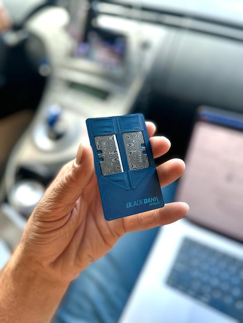 May include: A blue plastic card with a silver design and the text "BLADEBANK1. designs" printed on it.