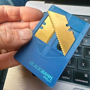 May include: A blue plastic card with a gold metal blade insert. The card has the text "BLADEBANK" and "Concept Designs" printed on it.