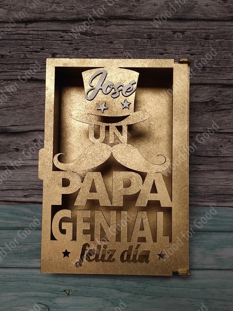 Może przedstawiać: Złoty drewniany znak z napisem "Jose UN PAPA GENIAL feliz dia" i wyciętym kapeluszem, wąsem i gwiazdami.