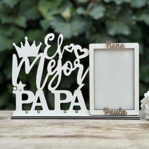 May include: White wooden picture frame with the words "El Mejor Papa" and a crown, heart, and star. The frame has two slots for photos and the words "Nene" and "Paula" are written on the frame.
