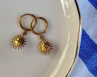 Pair of hoop earrings with golden sun pendant in stainless steel