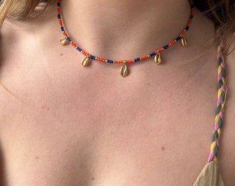 Choker ketting met donkerblauwe en oranje rocailles, gouden details met hanger 5 porceleinschelpen hangers koffiebonen