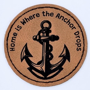 May include: A round, brown leather patch with a black anchor and the text "Home is Where the Anchor Drops".