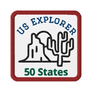 May include: A white embroidered patch with a red border. The patch features a black outline of a cactus and a mountain range with the text "US EXPLORER 50 States" in blue and green.