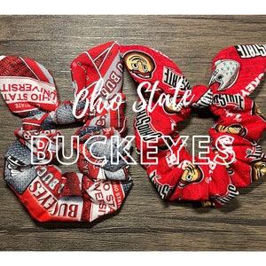 Könnte beinhalten: Zwei rote, weiße und graue Stoffhaargummis mit dem Aufdruck "Ohio State Buckeyes".