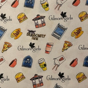May include: A white fabric with a repeating pattern of illustrations and text. The illustrations include a coffee cup, pizza slice, burger, gazebo, and a blue sign. The text includes "Gilmore girls", "Luke's", and "Dragonfly Inn".