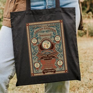May include: A black tote bag with a vintage-style illustration of a rabbit and the text "Cottontail Rabbit Fresh Garden Produce The Genuine Article Happiness Guaranteed Made with Love Radishes Carrots French Beans Gooseberries Pick Your Own".