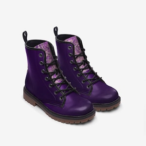 May include: Purple leather combat boots with black laces and a floral pattern lining. The boots have a rounded toe and a thick rubber sole.