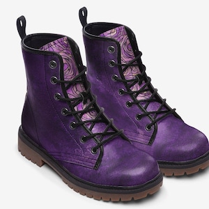 Könnte beinhalten: Lilafarbene Lederstiefel mit schwarzen Schnürsenkeln und einem rosa-violetten Blumenmuster auf der Innenseite des Stiefels.