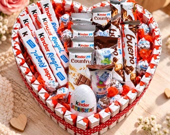 Pode incluir: Uma caixa de presente em forma de coração preenchida com um sortido de produtos de chocolate Kinder, incluindo barras Kinder Riegel, Kinder Country, Kinder Bueno, um ovo Kinder Überraschung e vários Kinder Schoko-Bons embalados individualmente.