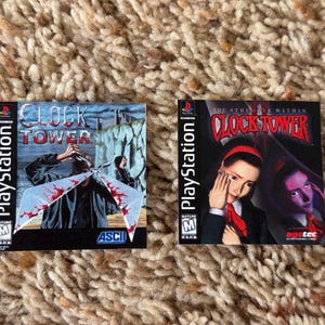 May include: Two PlayStation game cases. The first, "Clock Tower," features a figure with a bloody umbrella. The second, "Clock Tower 2," shows a woman with a red ribbon. Both cases have the PlayStation logo and a Mature rating.