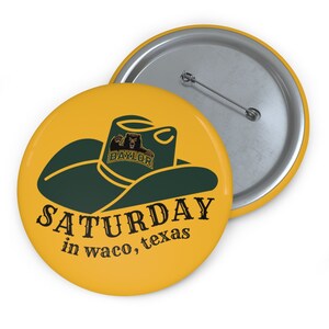 May include: A yellow button with a green cowboy hat and the Baylor University logo. The text "SATURDAY in waco, texas" is printed below the hat.