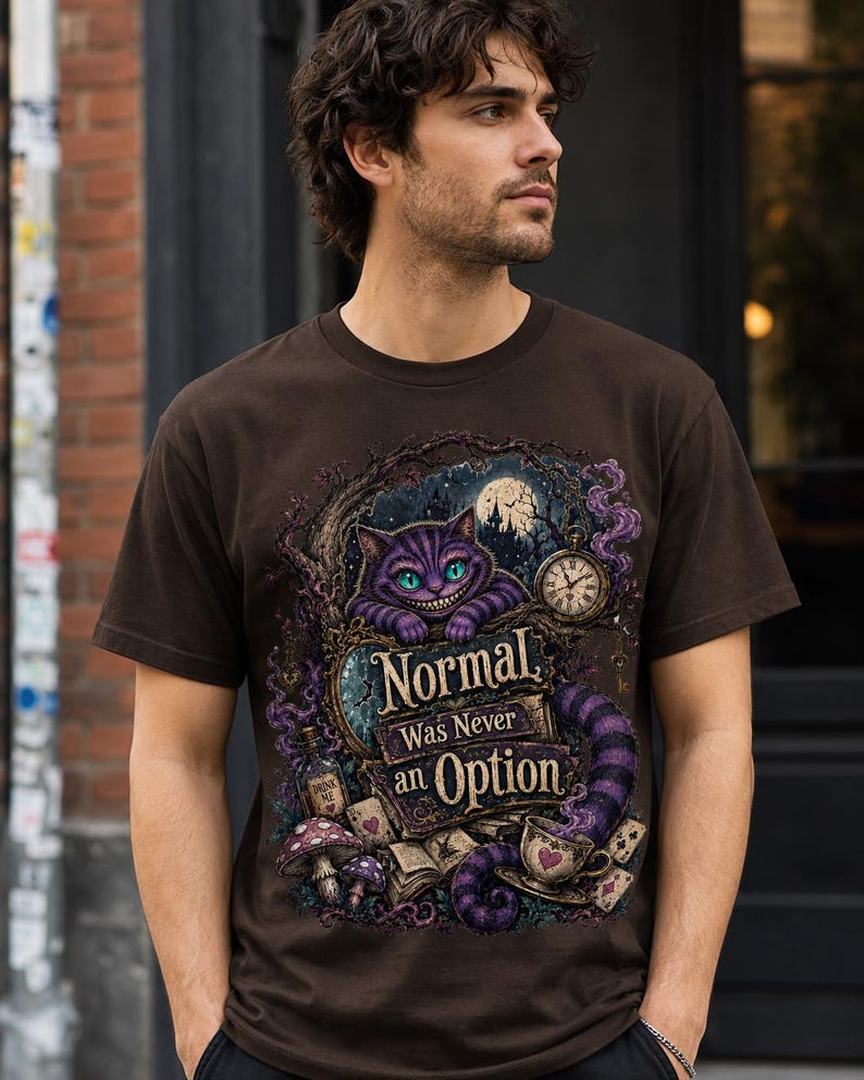 May include: A dark brown short-sleeve t-shirt featuring a graphic print of a purple striped cat with green eyes, a pocket watch, mushrooms, and a teacup. The text reads, "Normal Was Never an Option," surrounded by intricate, dark, fantasy-themed illustrations.