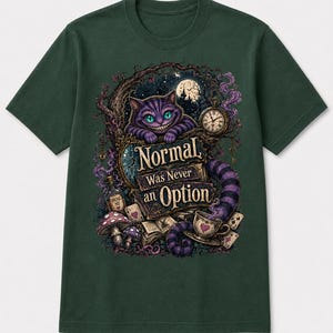 May include: A dark green short-sleeve t-shirt featuring a graphic print of a purple striped cat, a pocket watch, mushrooms, playing cards, and a bottle labeled Drink Me. The text reads Normal Was Never an Option in a decorative font style.