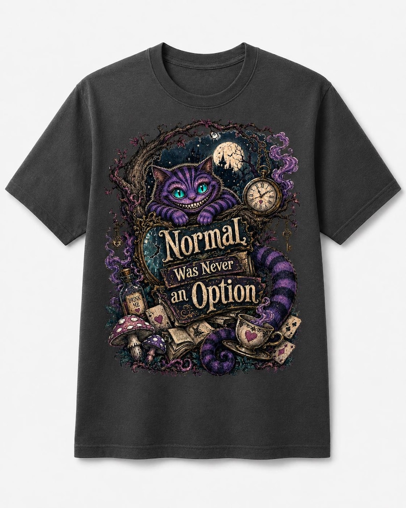 May include: A charcoal gray t-shirt featuring a graphic print of a purple striped cat with a wide grin, a pocket watch, a teacup, mushrooms, and playing cards. The text "Normal Was Never an Option" is printed in the center of the detailed illustration.