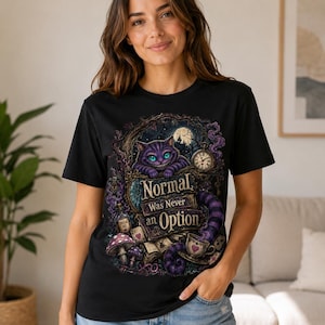 May include: A black short-sleeve t-shirt featuring a graphic print of a purple grinning cat, a pocket watch, a teacup, and mushrooms. The text reads, "Normal Was Never an Option," surrounded by intricate, dark, and whimsical fantasy-themed illustrations.