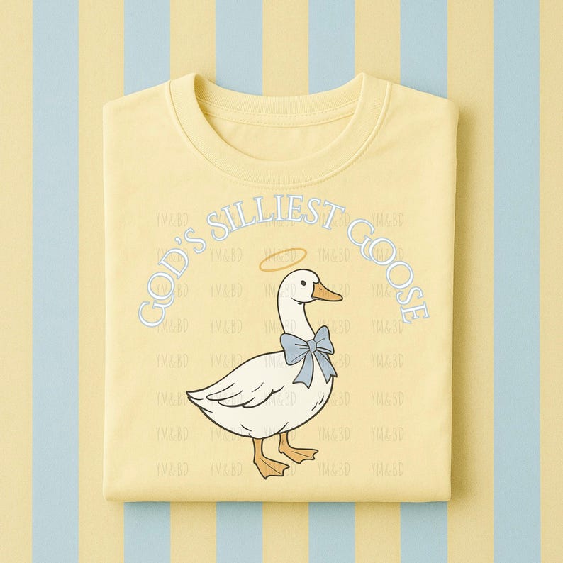 Może przedstawiać: Złożona, jasnoż&oacute;łta bluza z kapturem z kresk&oacute;wkową gęsią w niebieskiej muszce i aureoli. Tekst "GOD'S SILLIEST GOOSE" jest łukowato nad gęsią w jasnoniebieskim kolorze. Tło to wz&oacute;r w paski w kolorze ż&oacute;łtym i jasnoniebieskim.